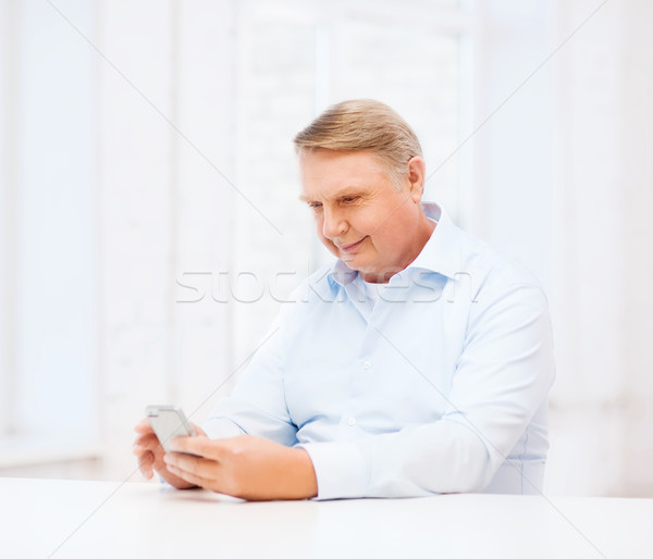 old man at home with smartphone Stock photo © dolgachov