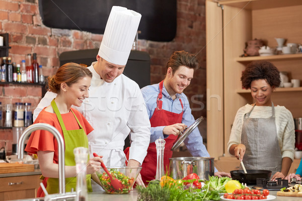 happy friends and chef cook cooking in kitchen Stock photo © dolgachov