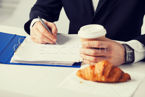 businessman with coffee writing something Stock photo © dolgachov