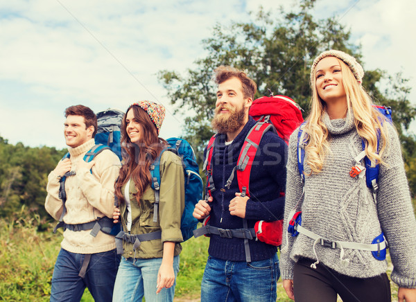 group of smiling friends with backpacks hiking Stock photo © dolgachov