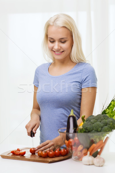 Stock photo: smiling young woman chopping vegetables at home