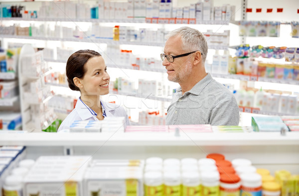 happy pharmacist talking to senior man at pharmacy Stock photo © dolgachov