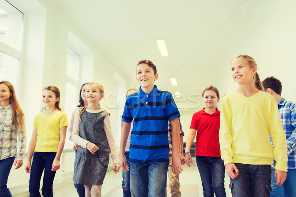 group of smiling school kids walking in corridor Stock photo © dolgachov