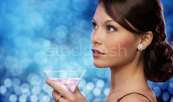 smiling woman holding cocktail over blue lights Stock photo © dolgachov