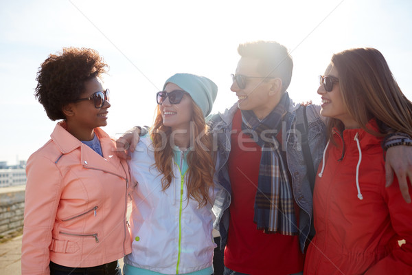 happy teenage friends in shades talking on street Stock photo © dolgachov