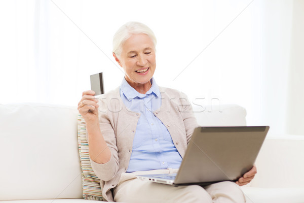 senior woman with laptop and credit card at home Stock photo © dolgachov