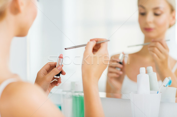 Stock photo: woman with lipstick and make up brush at bathroom