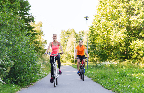 happy couple riding bicycle outdoors Stock photo © dolgachov