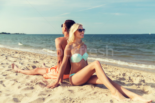 happy couple in swimwear sitting on summer beach Stock photo © dolgachov