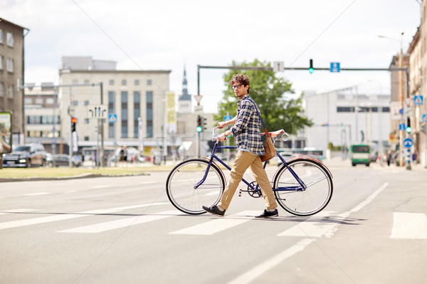 young man with fixed gear bicycle on crosswalk Stock photo © dolgachov