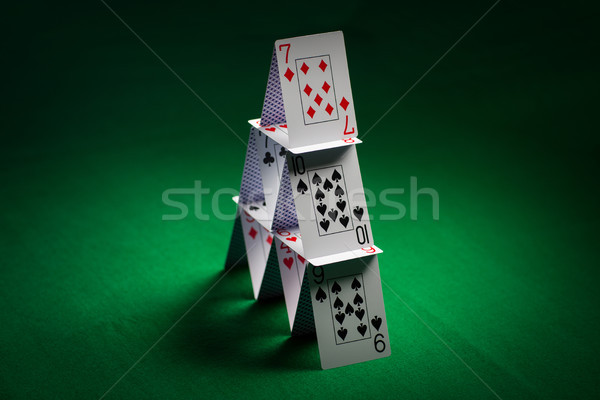 house of playing cards on green table cloth Stock photo © dolgachov