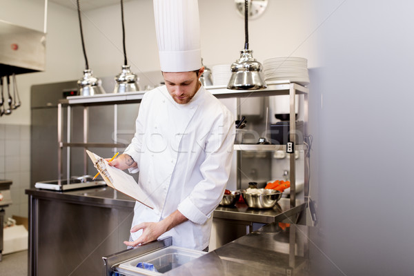 chef with clipboard doing inventory at kitchen Stock photo © dolgachov