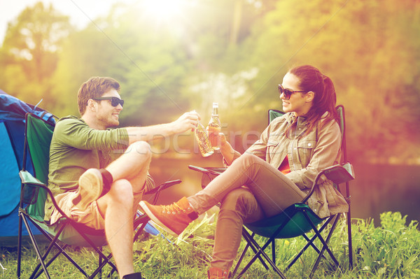 happy couple clinking drinks at campsite tent Stock photo © dolgachov