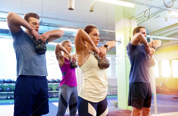 group of people with kettlebells exercising in gym Stock photo © dolgachov