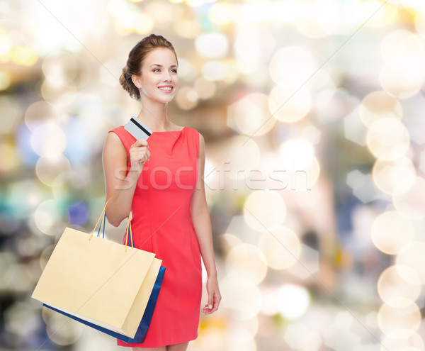 smiling woman with shopping bags and plastic card Stock photo © dolgachov