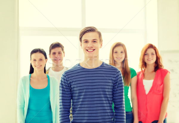 smiling students with teenage boy in front Stock photo © dolgachov