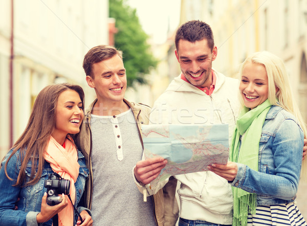 group of smiling friends with map and photocamera Stock photo © dolgachov