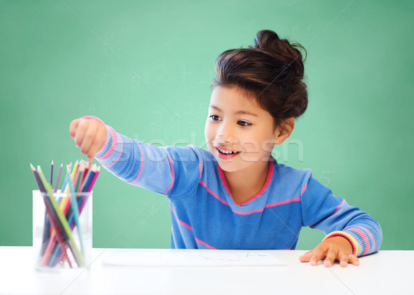 happy school girl drawing with coloring pencils Stock photo © dolgachov