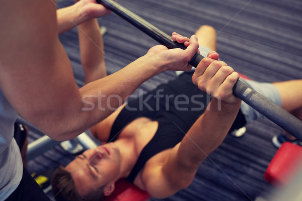 two young men with barbell flexing muscles in gym Stock photo © dolgachov
