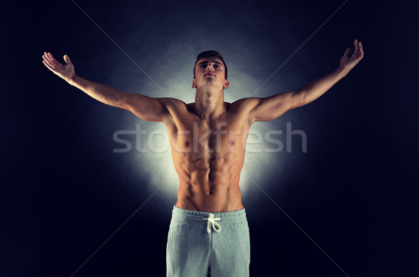 young male bodybuilder with raised hands Stock photo © dolgachov