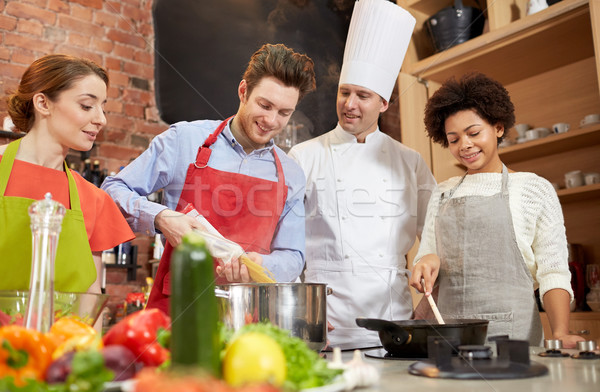 happy friends and chef cook cooking in kitchen Stock photo © dolgachov