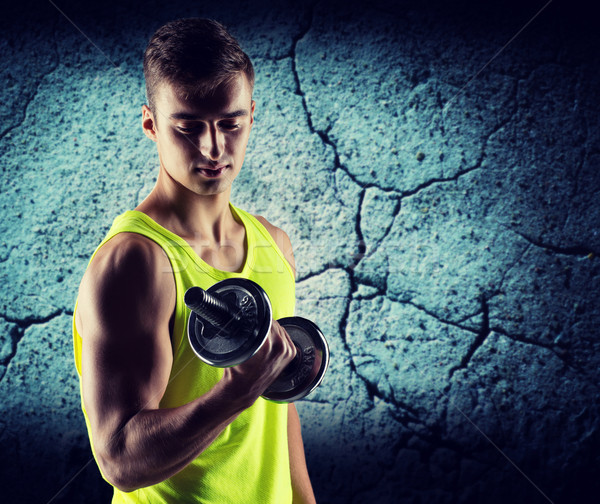Fiatalember súlyzó bicepsz sport testépítés képzés Stock fotó © dolgachov