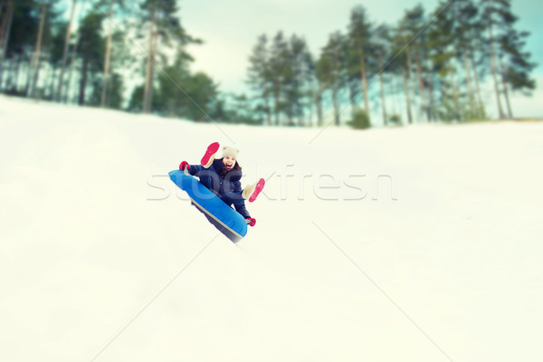 happy teenage girl sliding down on snow tube Stock photo © dolgachov