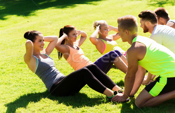 group of friends or sportsmen exercising outdoors Stock photo © dolgachov