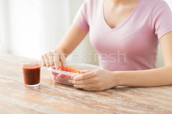 close up of woman with food in plastic container Stock photo © dolgachov