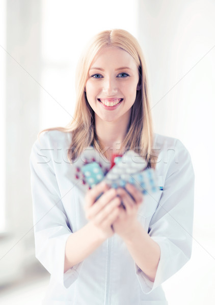 Stock photo: young female doctor with pack of pills