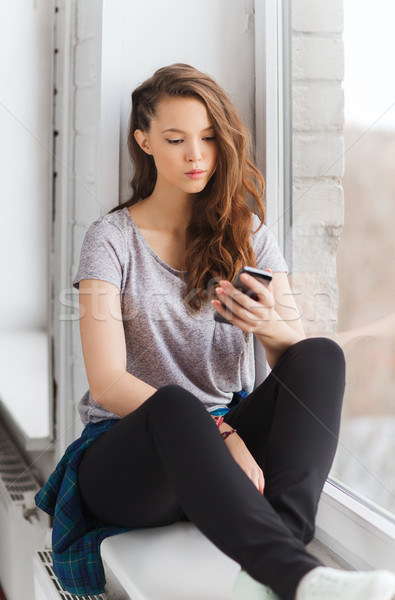 sad pretty teenage girl with smartphone texting Stock photo © dolgachov