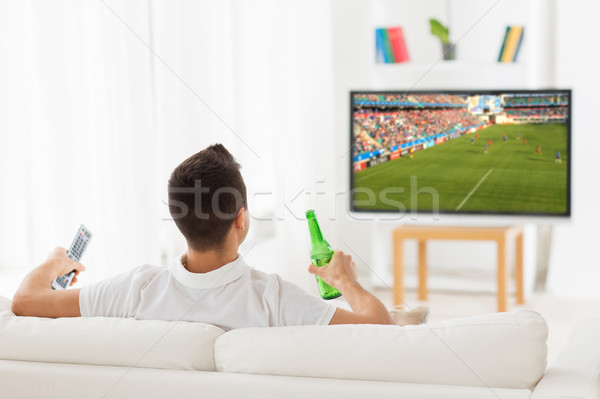 Stock photo: man watching soccer game on tv and drinking beer