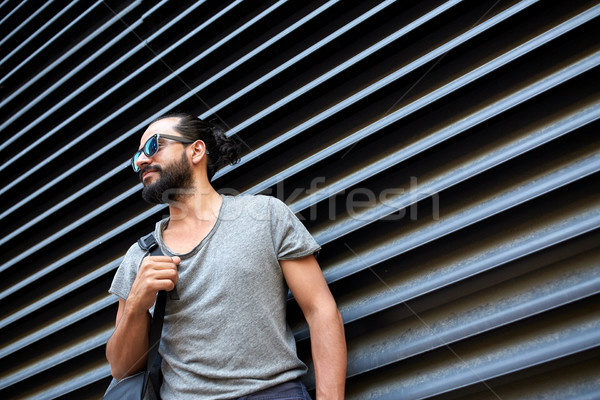 man with backpack standing at city street wall Stock photo © dolgachov