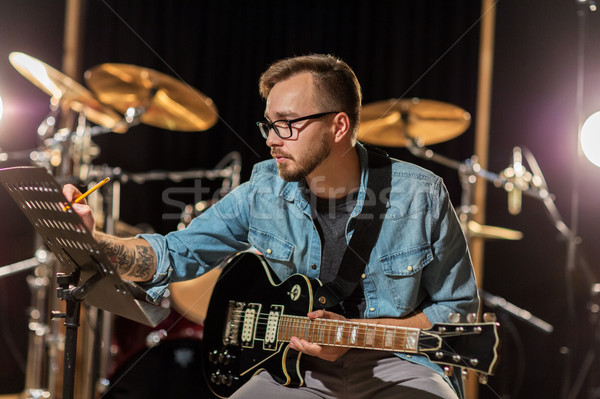 [[stock_photo]]: Homme · guitare · écrit · musique · livre · studio