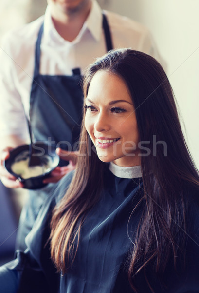happy young woman coloring hair at salon Stock photo © dolgachov
