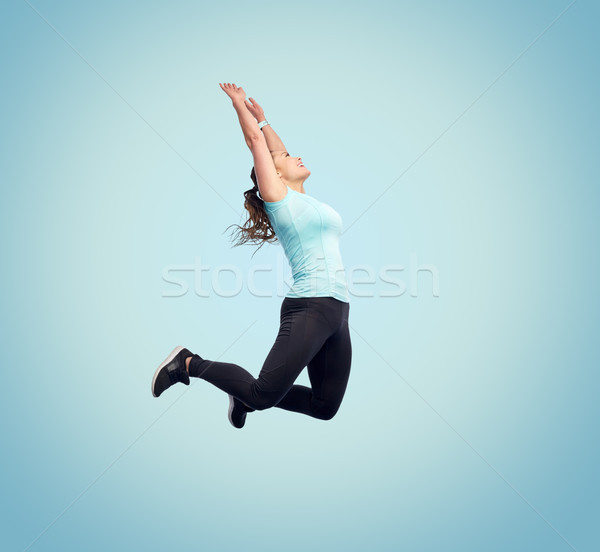 happy smiling sporty young woman jumping in air Stock photo © dolgachov