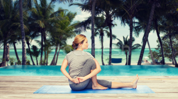 woman making yoga in twist pose on mat Stock photo © dolgachov