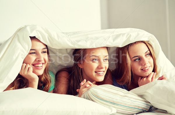 happy young women in bed at home pajama party Stock photo © dolgachov