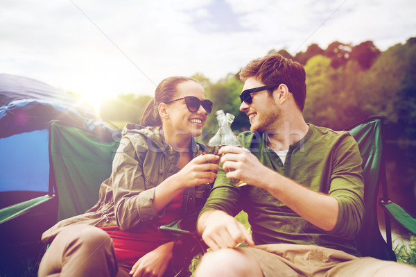 happy couple clinking drinks at campsite tent Stock photo © dolgachov