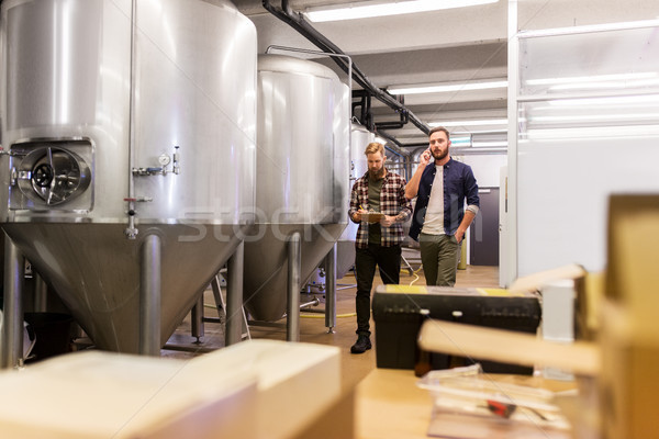 men working at craft brewery or beer plant Stock photo © dolgachov