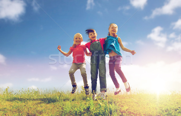 Foto stock: Grupo · feliz · crianças · saltando · alto · verde