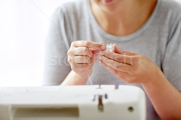 woman with spool of thread and sewing machine Stock photo © dolgachov