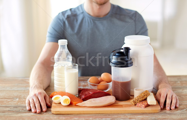 close up of man with food rich in protein on table Stock photo © dolgachov