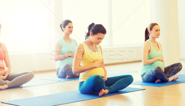 happy pregnant women exercising yoga in gym Stock photo © dolgachov