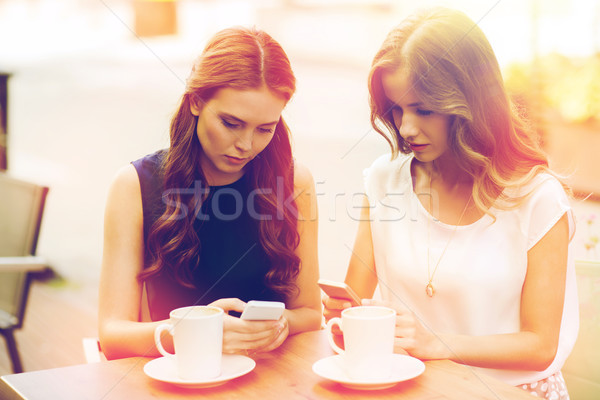 Stock photo: women with smartphones and coffee at outdoor cafe