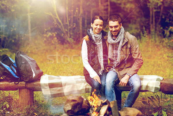 happy couple sitting on bench near camp fire Stock photo © dolgachov