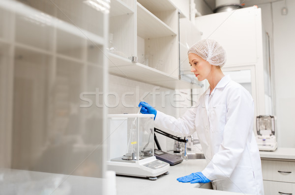 Stock photo: woman with sulphuric acid and scale at laboratory