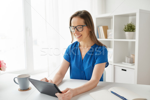 woman with tablet pc working at home or office Stock photo © dolgachov
