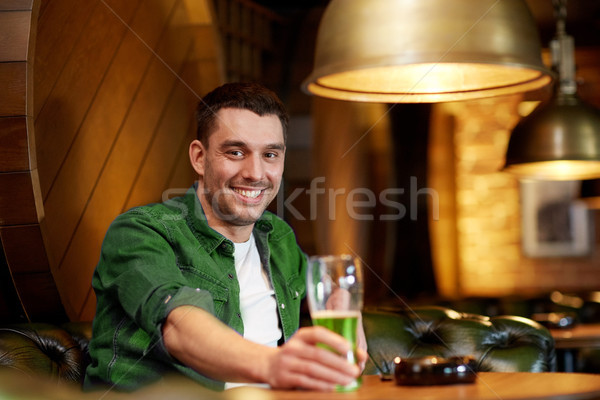 man drinking green beer at bar or pub Stock photo © dolgachov