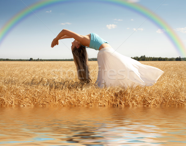 Stock photo: stretching woman with rainbow and water